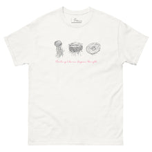 Load image into Gallery viewer, Mockup of a white t-shirt displayed flat, featuring minimalist line art of jellyfish and the phrase 'Floating like an Aegean thought' on the front