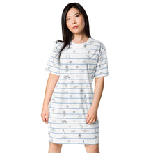 Load image into Gallery viewer, woman wearing our Unisex cotton t-shirt white dress with horizontal navy stripes and hand-drawn marine animal sketches, including octopuses and fish, creating a playful,Greek sea -inspired pattern