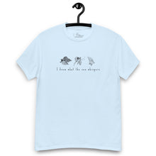 Load image into Gallery viewer, Light blue t-shirt featuring minimalist line drawings of clams (achivades) and sea snails, with the phrase &#39;I know what the sea whispers&#39; printed on the front.
