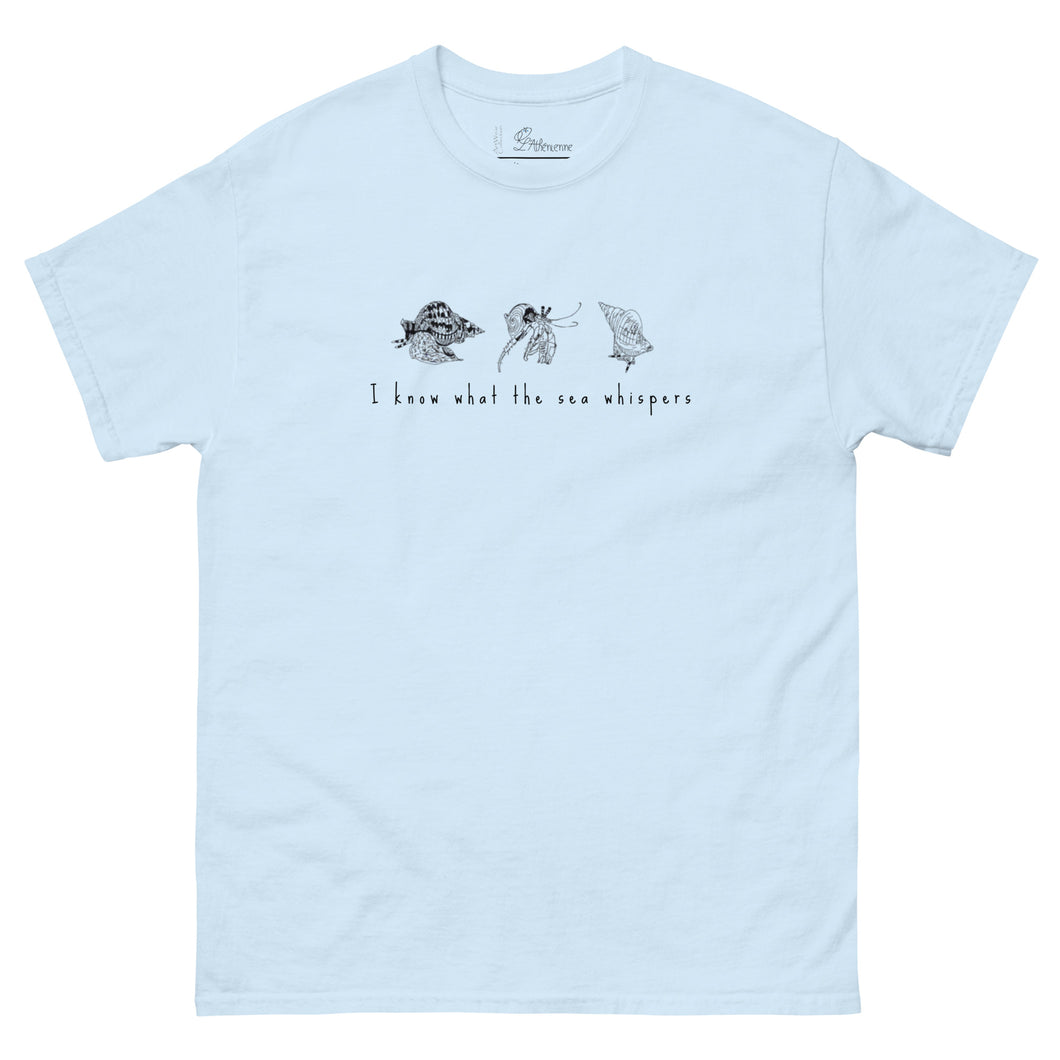 Light blue t-shirt featuring minimalist line drawings of clams (achivades) and sea snails, with the phrase 'I know what the sea whispers' printed on the front.