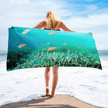 Load image into Gallery viewer, Premium beach towel inspired by Greece’s underwater world, featuring ocean-themed design and soft fabric laid near clear blue water
